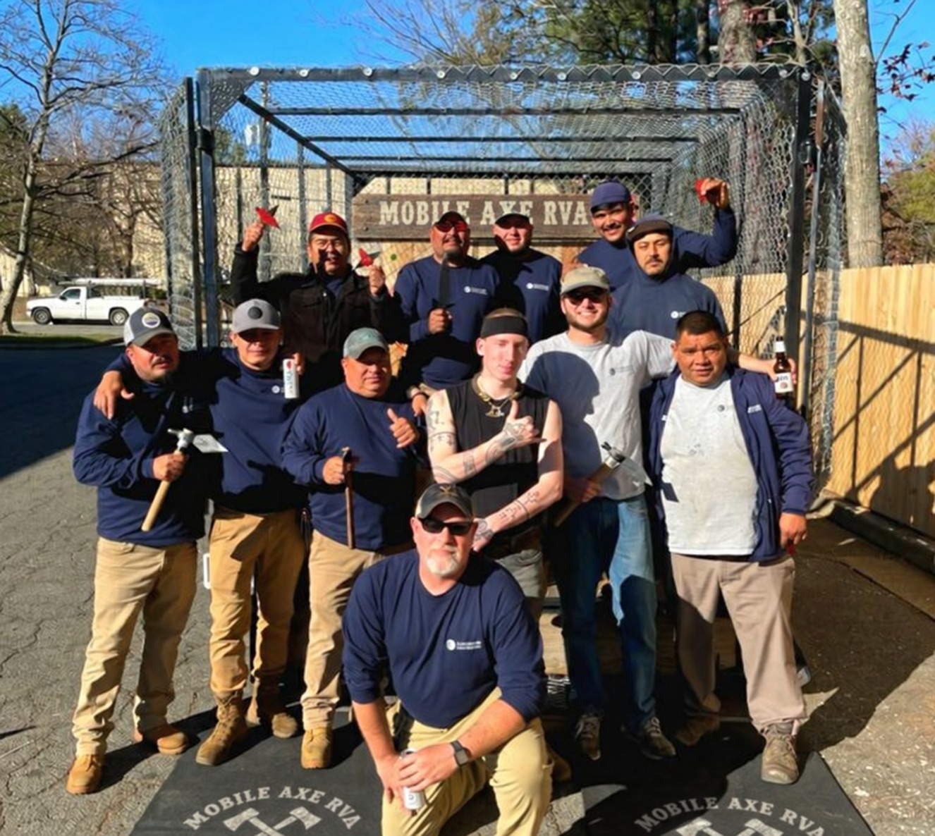Friends posing with axes at an outdoor Mobile Axe event