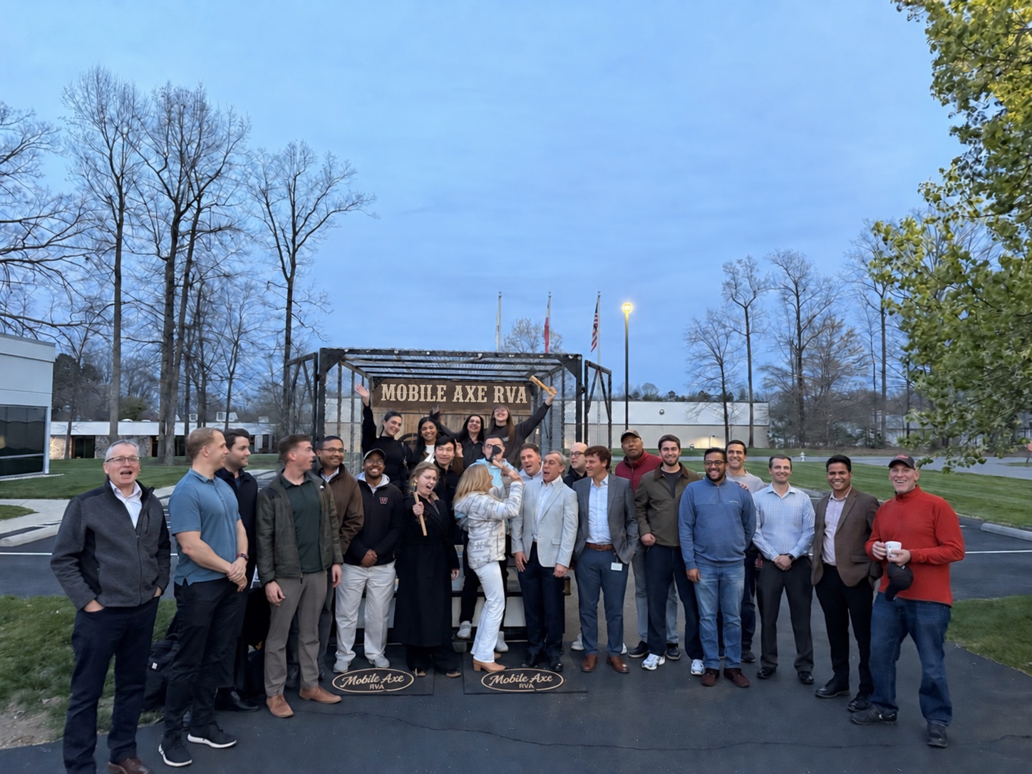 A group celebrating beside the Mobile Axe range at dusk