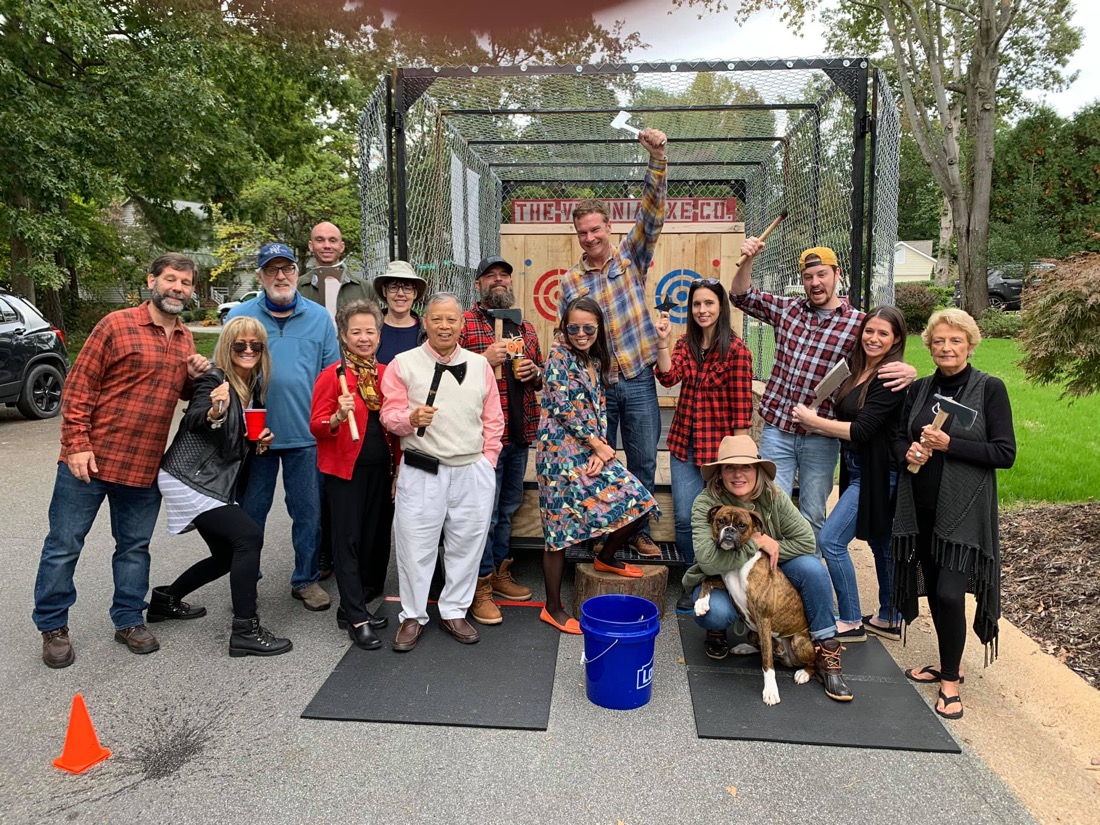 A big flannel-clad party group posing at the trailer with their dog